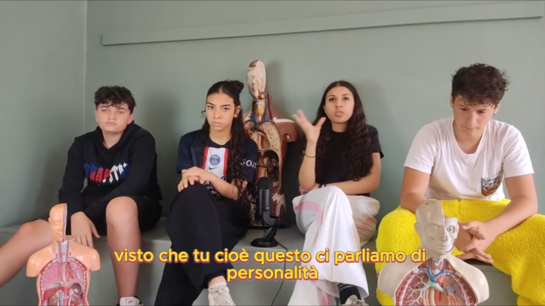Quattro allievi conversano davanti a un microfono e a modelli anatomici