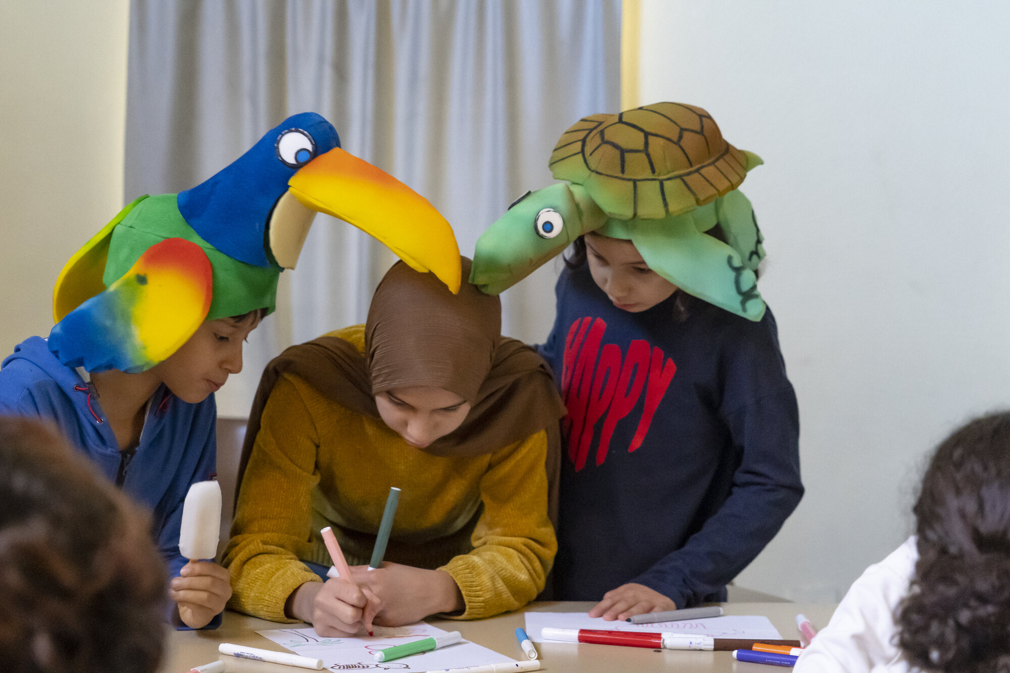Ragazze e ragazzi lavorano tra le creature della mostra