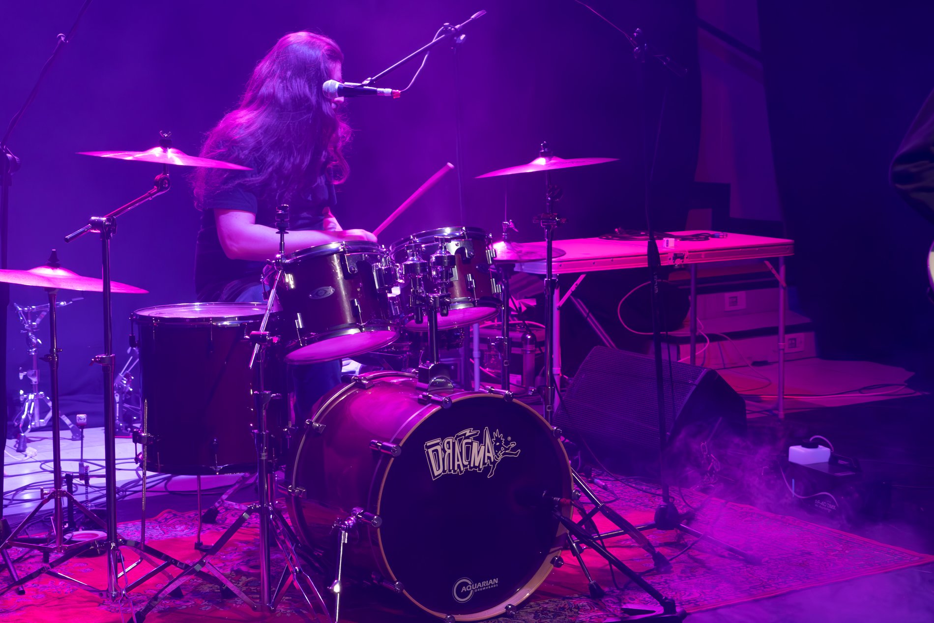 Batterista in concerto tra luci magenta al FAM Festival