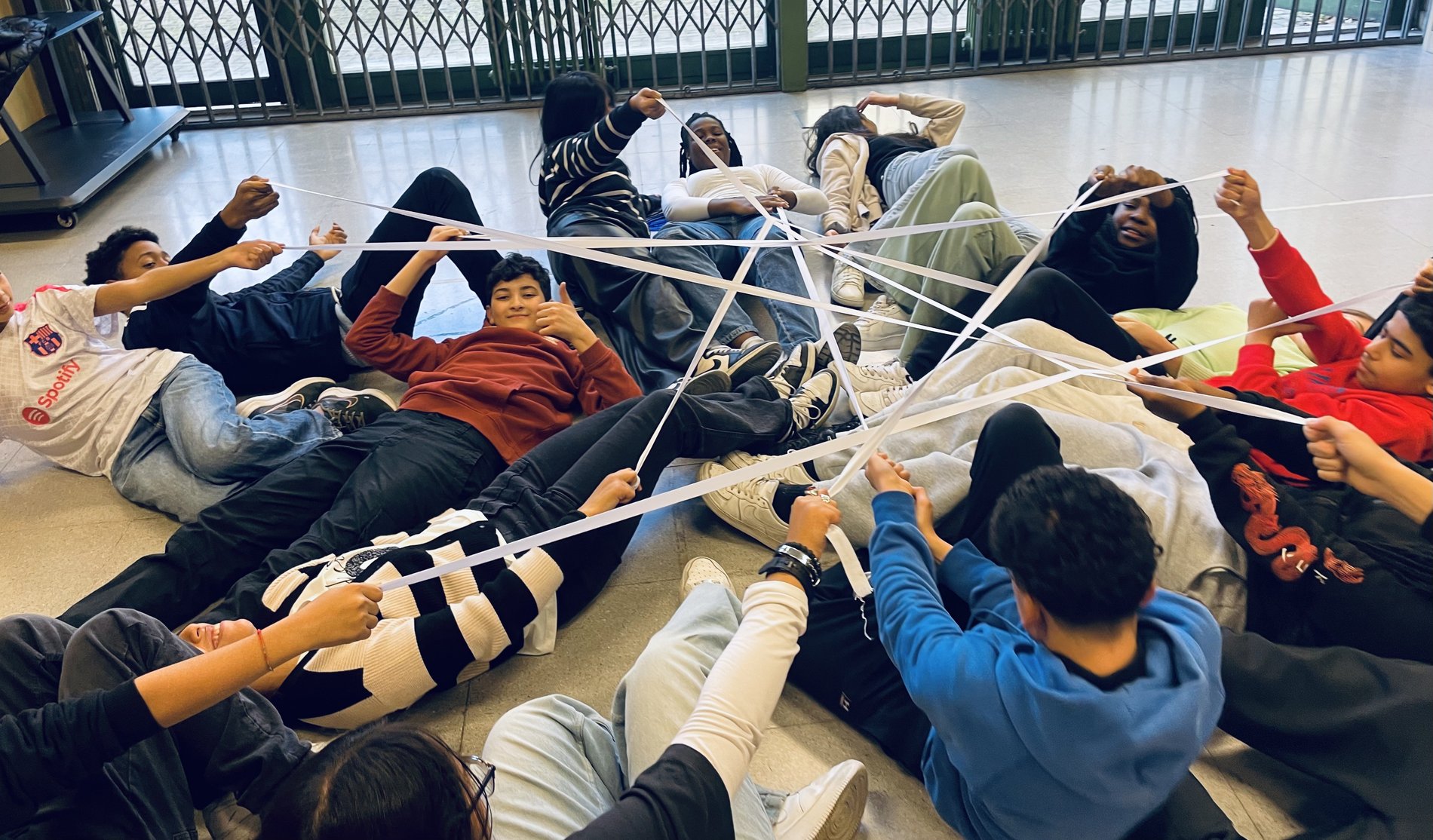 Il gruppo costruisce una rete di fili nel laboratorio teatrale