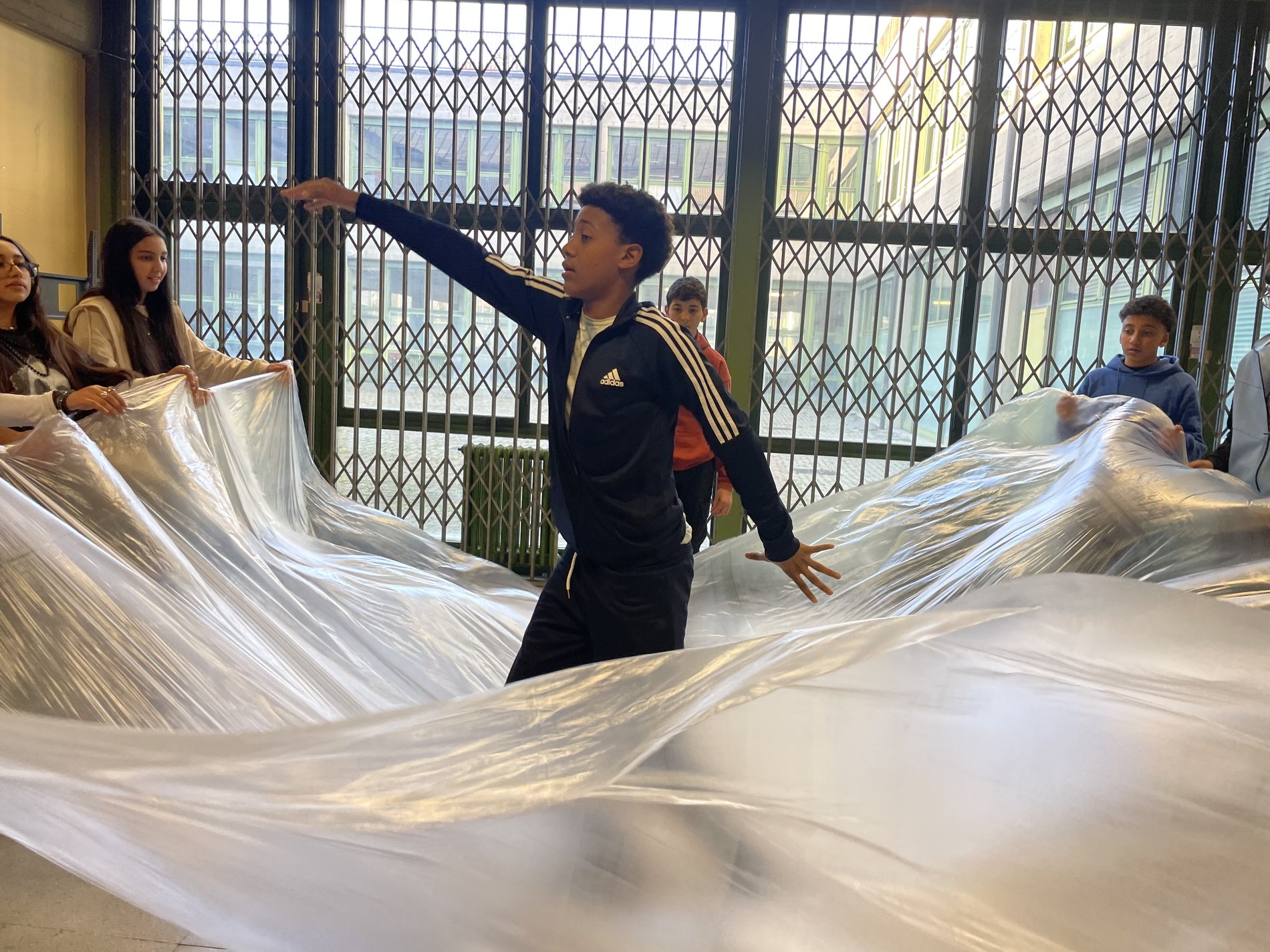 La classe lavora insieme con un grande tessuto nel laboratorio teatrale